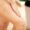 Beautiful young woman applying body scrub on leg at home