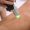 Close up shot of gloved hand with the laser hair removal machine's handpiece along woman leg.